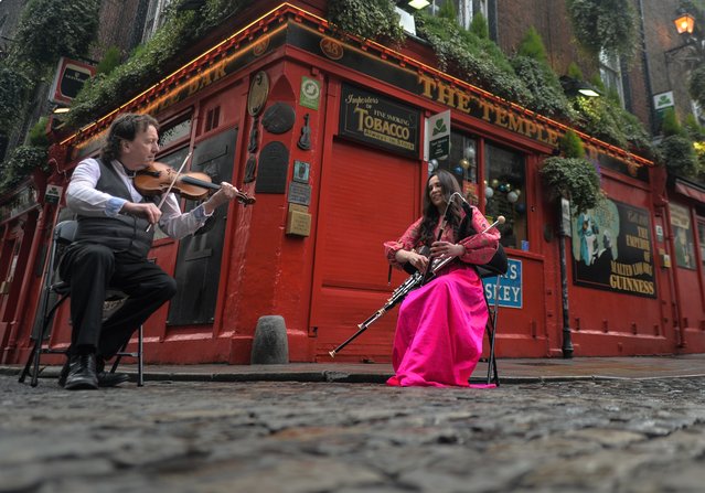 Exactly one year since the Temple Bar Area closed down due to COVID-19 pandemic, world-renowned fiddler Frankie Gavin performs a lament in Dublin's deserted Cultural Quarter in Ireland on Monday, 15 March, 2021. He is joined by piper Louise Mulcahy. (Photo by Artur Widak/NurPhoto/Rex Features/Shutterstock)