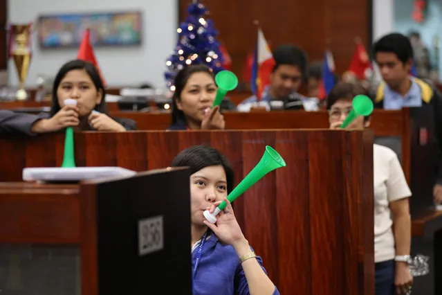 Filipino traders blow plastic horns during celebrations marking the last trading day of the year 2015 at the Philippine Stock Exchange (PSE) in the financial district of Makati, south of Manila, Philippines, 29 December 2015. The PSE index closed at 6,952.08, down 31.53 points or 0.45 per cent. (Photo by Mark R. Cristino/EPA)