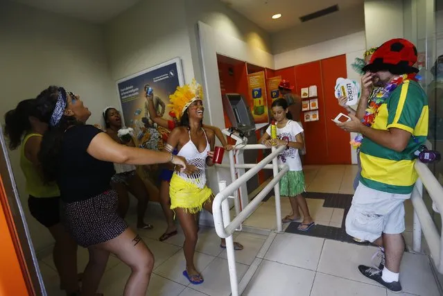 Revellers dance inside a bank during the annual block party known as the “Suvaco do Cristo” (Armpit of Christ), one of the many pre-carnival parties to take place in the neighbourhoods of Rio de Janeiro, February 8, 2015. (Photo by Ricardo Moraes/Reuters)