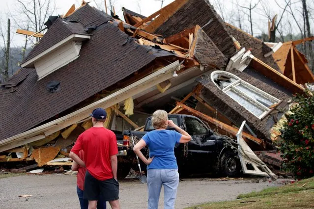 Residents survey damage to homes after a tornado touched down south of Birmingham, Ala. in the Eagle Point community damaging multiple homes, Thursday, March 25, 2021. Authorities reported major tornado damage Thursday south of Birmingham as strong storms moved through the state. The governor issued an emergency declaration as meteorologists warned that more twisters were likely on their way. (Photo by Butch Dill/AP Photo)