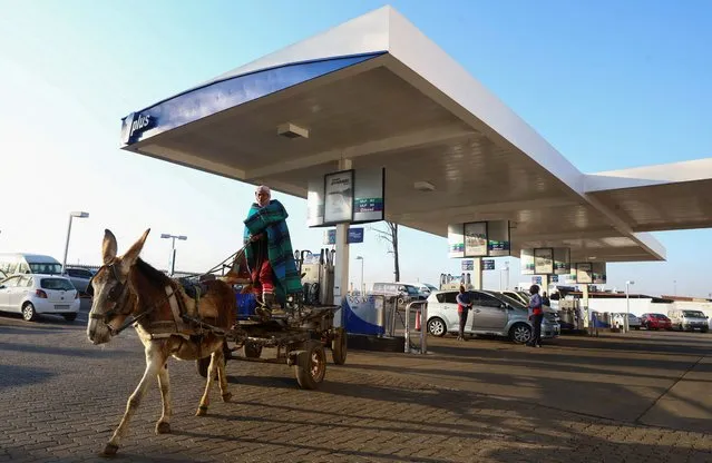 A man leaves a petrol station after checking the tyre pressure on his donkey cart in Soweto, Johannesburg, South Africa on July 28, 2023. (Photo by Siphiwe Sibeko/Reuters)