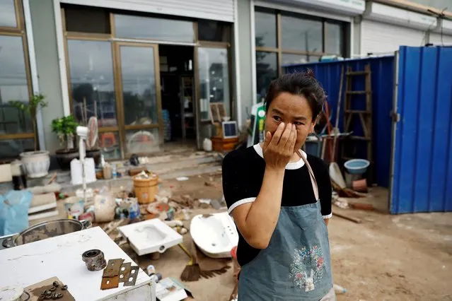 Li Yujie, 47, weeps outside her flood-stricken hardware store after the rains and floods brought by remnants of Typhoon Doksuri, in Zhuozhou, Hebei province, China on August 7, 2023. (Photo by Tingshu Wang/Reuters)