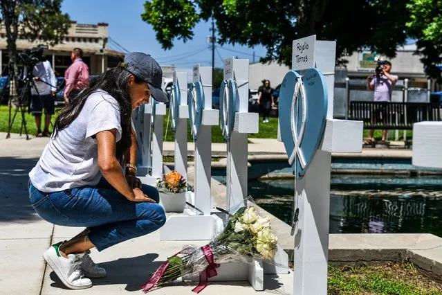 Britain's Meghan, Duchess of Sussex, places flowers as she mourns at a makeshift memorial outside Uvalde County Courthouse in Uvalde, Texas, on May 26, 2022. Grief at the massacre of 19 children at the elementary school in Texas spilled into confrontation on May 25, as angry questions mounted over gun control -- and whether this latest tragedy could have been prevented. The tight-knit Latino community of Uvalde on May 24 became the site of the worst school shooting in a decade, committed by a disturbed 18-year-old armed with a legally bought assault rifle. (Photo by Chandan Khanna/AFP Photo)
