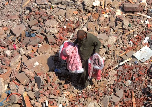 A man walks on the rubble of a collapsed apartment building in the el-Salam neighborhood, in Cairo, Egypt, Saturday, March 27, 2021. A nine-story apartment building collapsed in the Egyptian capital early Saturday, killing at several and injuring about two dozen others, an official said. (Photo by Tarek Wajeh/AP Photo)