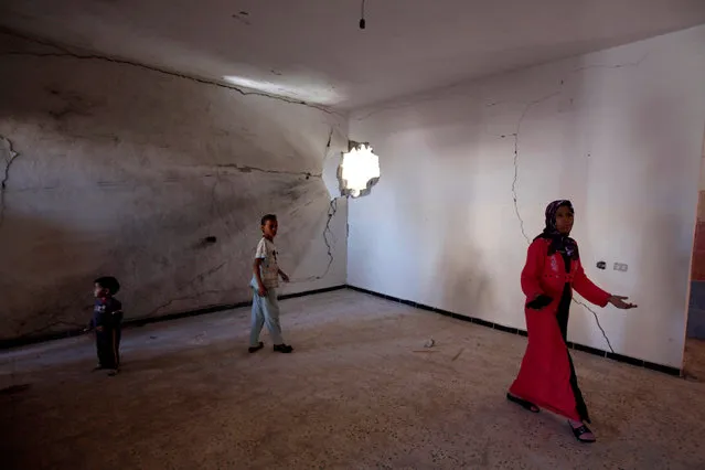 A family inspect their house, which they had left due to fighting between pro and anti-Gaddafi fighters, upon their return to Sirte, Libya October 26, 2011. (Photo by Youssef Boudlal/Reuters)