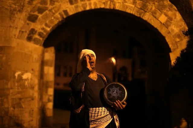 A Palestinian Mesaharati holds a drum as he calls out to wake up Muslims to have the predawn meal before they start their long-day fast during Ramadan in Khan Younis in the southern Gaza Strip on April 15, 2021. (Photo by Ibraheem Abu Mustafa/Reuters)