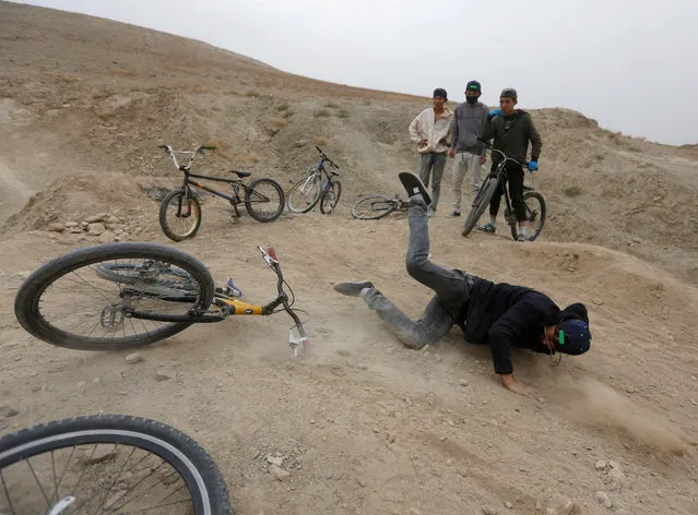 A young Afghan cyclist falls down from his bicycle during an exercise on the outskirts of Kabul, Afghanistan November 20, 2016. (Photo by Omar Sobhani/Reuters)