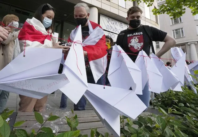 Protesters attach paper planes during a demonstration of Belarusians living in Poland and Poles supporting them in front of European Commission office in Warsaw demanding freedom for Belarus opposition activist Raman Protasevich in Warsaw, Poland, Monday, May 24, 2021. Western outrage grew and the European Union threatened more sanctions Monday against Belarus over its forced diversion of a passenger jet to the capital of Minsk in order to arrest opposition journalist Raman Protasevich in a dramatic gambit that some said amounted to state terrorism or piracy. (Photo by Czarek Sokolowski/AP Photo)