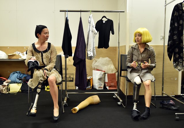 Paralympic athlete Sayaka Murakami (L) and Paralympic snowboarder Mika Abe (R) chat as they wait backstage to take part in a fashion show for the “tenbo” brand, designed by Japanese designer Takafumi Tsuruta, during the Tokyo Fashion Week's 2015-16 autumn/winter collection in Tokyo on March 18, 2015.  Tsuruta designed the line of outfits for all people, including those with disabilities, using items such as magnetic buttons for users to put and take off clothes easily. (Photo by Yoshikazu Tsuno/AFP Photo)