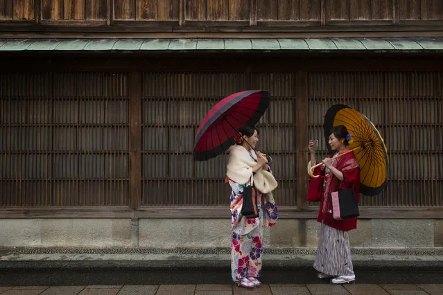 Young women celebrating the coming of age wear traditional japanese attire while visiting the Higashi-Chaya-gai is a historic geisha tea house district in Kanazawa, Japan on January 8, 2016. Some have been converted into homes, others into shops that sell trinkets or sweets. (Photo by Linda Davidson/The Washington Post)