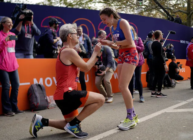 Adam Kipiniak proposes to Emily Goldsmith at the finish line of the New York City Marathon, in Central Park, on November 5, 2023. (Photo by Eduardo Munoz/Reuters)