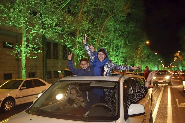 Iranians flash the victory sign from their car while celebrating at a street in northern Tehran, Iran, Thursday, April 2, 2015, after Iran's nuclear agreement with world powers in Lausanne, Switzerland. (Photo by Vahid Salemi/AP Photo)