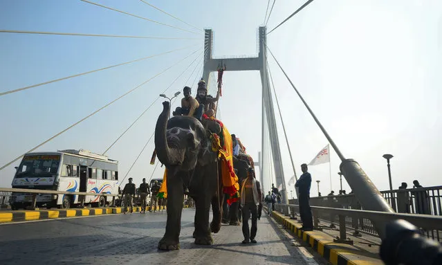 Indian Hindu Sadhus (holy men) from the Avahan Akhara ride on an elephant as they take part in a religious procession towards the Sangam area during the first “royal entry” for the Kumbh Mela in Allahabad on December 27, 2018. (Photo by Sanjay Kanojia/AFP Photo)