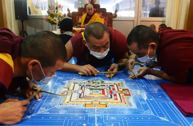 Tibetan Spiritual Leader The Dalai Lama looks on as Tibetan Buddhist monks work on a traditional painting during a special religious prayer during the Kalachakra event at Bodhgaya on January 5, 2017. (Photo by Dibyangshu Sarkar/AFP Photo)