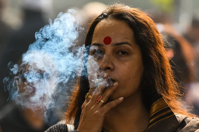 A member of the Indian transgender community smokes a cigarette as she protests against the Transgender Persons (Protection of Rights) Bill in New Delhi on December 28, 2018. The activists are protesting the recently passed Transgender Persons (Protection of Rights) Bill including provisions for “screening committees” to verify transgender identity, the criminalising of begging, and the lack of promises of reservations for employment or education. (Photo by Chandan Khanna/AFP Photo)