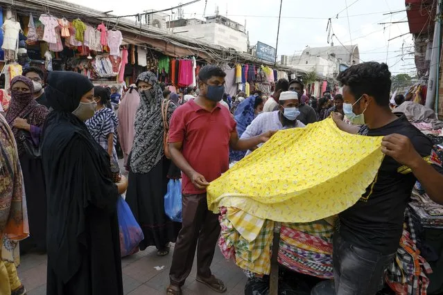 People shop at a market ahead of Eid-al Adha in Dhaka, Bangladesh, Friday, July 16, 2021. (Photo by Mahmud Hossain Opu/AP Photo)