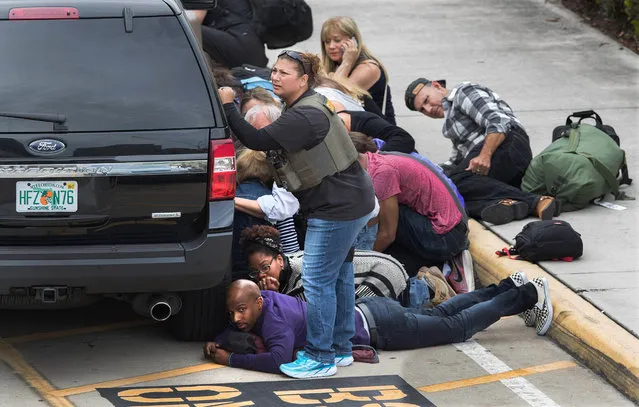 People take cover at the Ft. Lauderdale Airport after a gunman killed 5 people and injured many more on January 6, 2017. A gunman killed five people and injured eight Friday at Fort Lauderdale-Hollywood International Airport, which was forced to shut down and thrust into chaos. The suspect was identified as Esteban Santiago. (Photo by Allen Eyestone/The Palm Beach Post via ZUMA Wire)