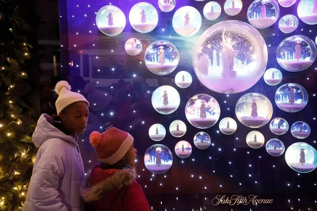 People gather as Saks Fifth Avenue unveils its 2023 holiday windows on November 20, 2023 in New York City. (Photo by John Lamparski/Getty Images)