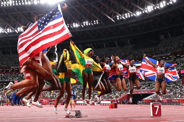 Briana Williams, Elaine Herah-Thompson, Shelly-Ann Fraser-Pryce and Shericka Jackson of Jamaica celebrate with their national flags after winning gold, Javianne Oliver, Teahna Daniels, Jenna Prandini and Gabrielle Thomas of the United States celebrates winning the silver medal, and Asha Philip, Imani Lansiquot, Dina Asher-Smith and Gabrielle Thomas of the United States celebrate winning the bronze medal in the women's 4 X 100m relay on day fourteen of the Tokyo 2020 Olympic Games at Olympic Stadium on August 6, 2021 in Tokyo, Japan. (Photo by Lucy Nicholson/Reuters)