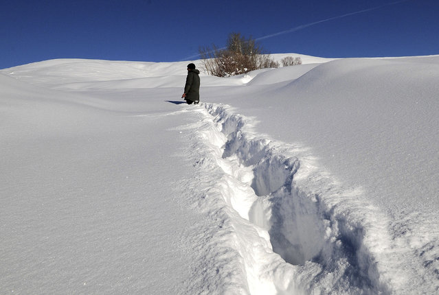 A villager walking through deep snow in Disbudak village of Bingol province located in Eastern Anatolia Region, Turkey on January 11, 2019. (Photo by Abdullah Celik/Anadolu Agency/Getty Images)