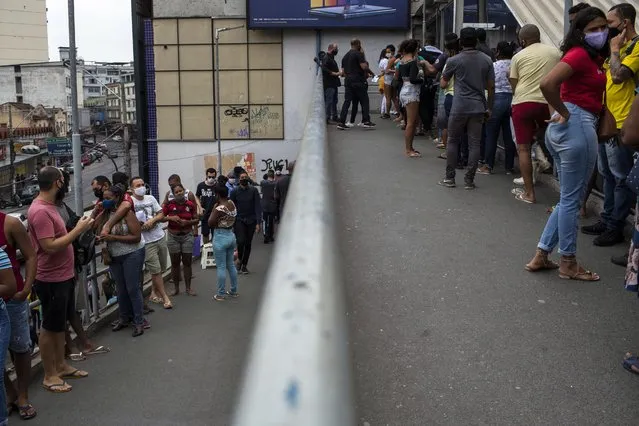 People line up on a train station ramp for COVID-19 vaccine shots at the station hosting a vaccine campaign for people over age 20 in Duque de Caxias, Brazil, Wednesday, August 11, 2021. (Photo by Bruna Prado/AP Photo)