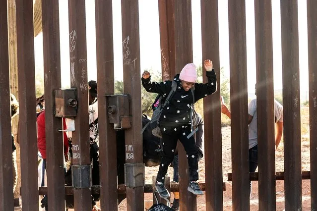 A migrant child jumps to cross the border wall through a gap into the U.S. from Mexico, as the number of migrants surges in the border town of Lukeville, Arizona, U.S. December 12, 2023. (Photo by Go Nakamura/Reuters)