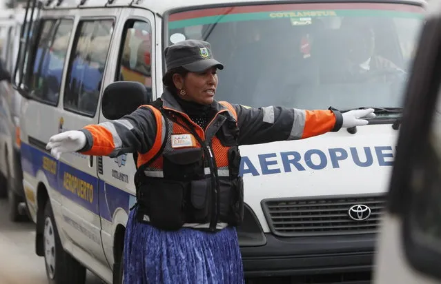 In this December 13, 2013 photo, an Aymara woman uses hand-and-arm signals to direct traffic in El Alto, Bolivia. (Photo by Juan Karita/AP Photo)