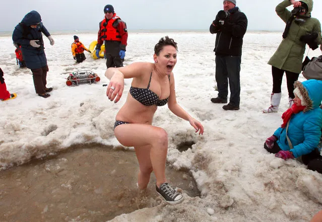 Resl Weigel, of Milwaukee screams as she leaves the icy water after taking a plunge. The annual Polar Bear Plunge in Milwaukee was held at Bradford Beach on Wednesday, January 1, 2014. (Photo by Mike De Sisti)
