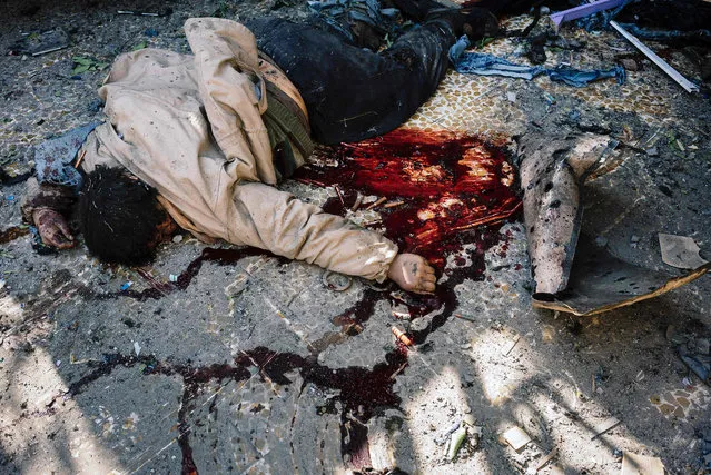 The body of a suspected Islamic State (IS) group fighter lies on the ground in Mosul's al-Sahiroun neighbourhood on January 12, 2017, during a military operation by Iraqi security forces against IS militants. Iraqi government forces launched a major offensive to recapture Mosul from the Islamic State group on October 17, 2016. Since then, they have retaken many areas in the eastern parts of Iraq's second city, but districts to the west of the Tigris River are still firmly in IS hands. (Photo by Dimitar Dilkoff/AFP Photo)