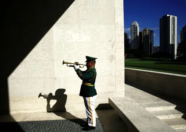 A Filipino soldier plays “Taps” on his trumpet along a hall of walls with names of “Missing in Action” soldiers during a ceremony on the eve of Veterans Day, at the Manila American Cemetery and Memorial in Taguig City, Metro Manila, Philippines, 10 November 2023. The US ambassador to the Philippines, MaryKay Loss Carlson, joined the surviving war veterans in rites to honor American and Filipino troops killed in World War II at the cemetery, where more than 17,000 American military and 570 Filipino counterparts are buried. (Photo by Francis R. Malasig/EPA)
