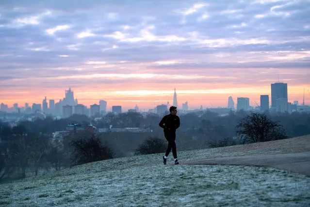 A man runs across a frosty Primrose Hill in London, UK at sunrise January 23, 2019. The Met Office issued yellow severe ice warnings for the south-east, central and north of England, as well as for Scotland. (Photo by Victoria Jones/PA Wire Press Association)