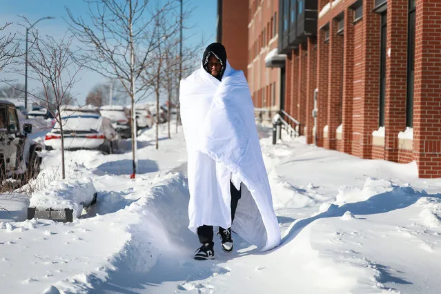Diamani Glo bundles up in a blanket as he walks in –12 degree weather on January 14, 2024, in Des Moines, Iowa. A passing weather system brought snowfall and subzero temperatures to Iowa as voters prepare for the Republican Party of Iowa's presidential caucuses on January 15th. (Photo by Joe Raedle/Getty Images)