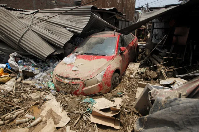 A car is seen among debris after a landslide and a flood occurred in San Juan de Lurigancho distritct, in Lima, Peru February 1, 2017. (Photo by Guadalupe Pardo/Reuters)