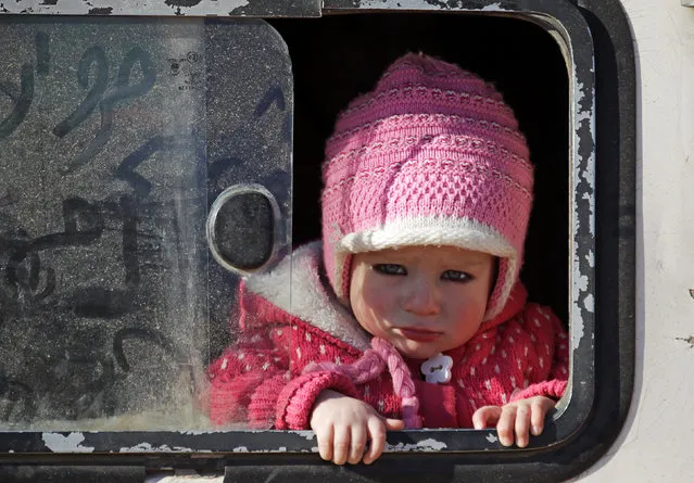 A child, who fled with others from Islamic State-controlled northern Syrian town of al-Bab, looks out from a bus upon arrival to the rebel-held outskirts of the town, Syria February 3, 2017. (Photo by Khalil Ashawi/Reuters)