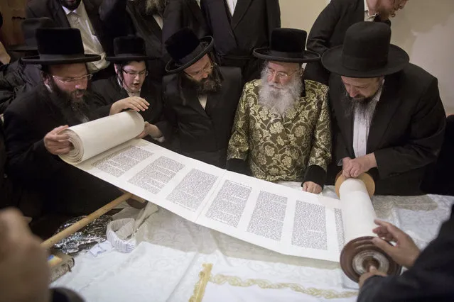 An ultra-Orthodox Jewish rabbi writes a new Torah scroll near the Western Wall, the holiest place for Jews, at the Old City of Jerusalem, Israel, 16 March 2016. Many Jews gathered for a special march around the Old City to celebrate the writting of a new Torah scroll. According to the rabbis the scroll was written for the purpose of holding a mass prayer of Jews from around the world, in order to stop the latest attacks on Jews by  Palestinians (Photo by Abir Sultan/EPA)