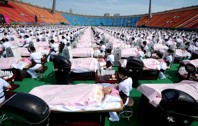 A group of 1000 customers receive facial massage at a sports centre in Jinan, Shandong province, China, May 4, 2015. A group of 1000 women were given a 30 minutes facial beauty treatment together on Monday that achieved a Guinness record for the largest group of people having beauty treatment in the same location, according to local media. (Photo by Reuters/Stringer)