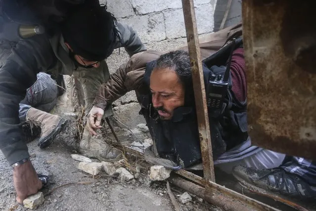 Syrian rebels help evacuate a comrade who was hit by sniper fire as the group prepared an attack on a government controlled army checkpoint in the Ain Tarma neighborhood of Damascus on January 30, 2013. (Photo by Goran Tomasevic/World Press Photo)