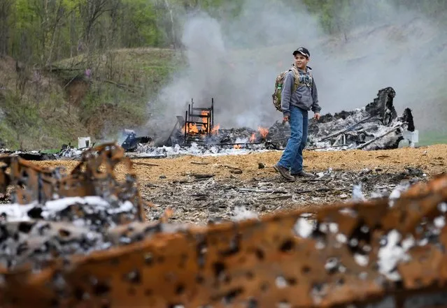 A boy walks through destruction on the main firing line during a break in the shooting at the Knob Creek Machine Gun Shoot and Military Gun show in Bullitt County near West Point, Kentucky on April 12, 2019. (Photo by Andrew Caballero-Reynolds/AFP Photo)
