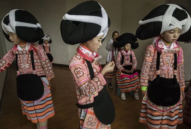 Teenage girls of the Long Horn Miao ethnic minority group wear headdresses as they prepare to celebrate Tiaohua or Flower Festival as part of the Lunar New Year  on February 6, 2017 in Longga village, Guizhou province, southern China. (Photo by Kevin Frayer/Getty Images)