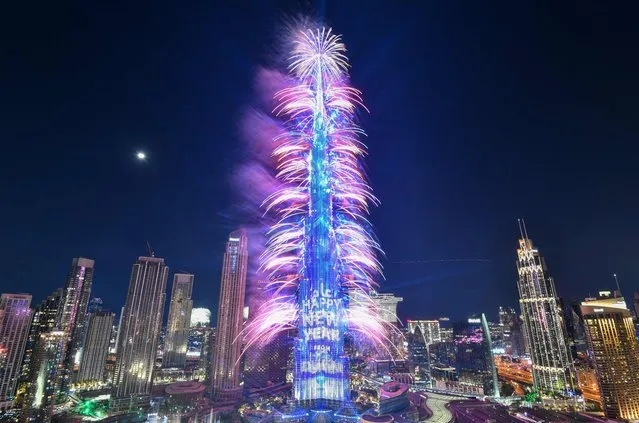 New Year's Eve fireworks light the landmark Burj Khalifa tower at midnight in the Gulf emirate of Dubai on December 31, 2022. (Photo by Ryan Lim/AFP Photo)