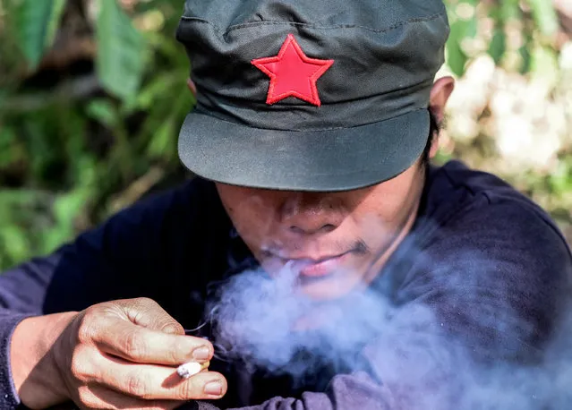 A fighter of the New People's Army-Melito Glor Command (NPA-MGC) smokes a cigarette at an undisclosed location in the mountains of Sierra Madre, Philippines, 31 March 2019. The rebels have negotiated unsuccessfully with five Filipino presidents before the current leader, Rodrigo Duterte. The NPA had about 60 fighters, nine automatic rifles and 26 single-shot rifles and pistols when it was established in 1969, before gradually growing and expanding. (Photo by Alecs Ongcal/EPA/EFE)