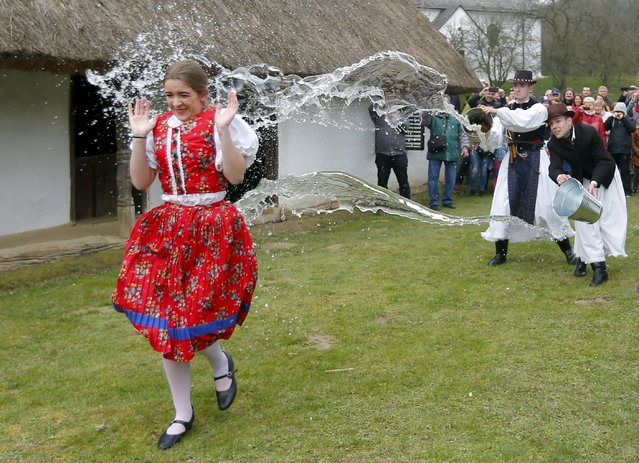 Men throw water on a woman as part of traditional Easter celebrations in Szenna, Hungary, March 28, 2016. (Photo by Laszlo Balogh/Reuters)