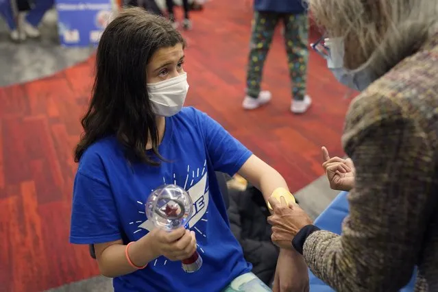 Jehna Kottori, 10, of Worcester, Mass., prepares to receive a shot of the Pfizer COVID-19 vaccine, Thursday, December 2, 2021, at a mobile vaccination clinic in Worcester. As the U.S. recorded its first confirmed case of the omicron variant, doctors across the country are experiencing a more imminent crisis with a delta variant that is sending record numbers of people to the hospital in New England and the Midwest. (Photo by Steven Senne/AP Photo)