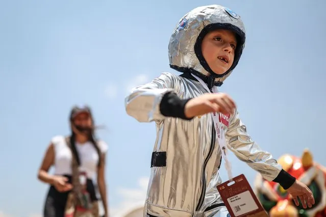 A child dressed as an astronaut attends an Astronomy Festival that brings together astronomy professionals and enthusiasts to share knowledge about the universe in Villa de Leyva, Colombia, Saturday, March 16, 2024. (Photo by Ivan Valencia/AP Photo)