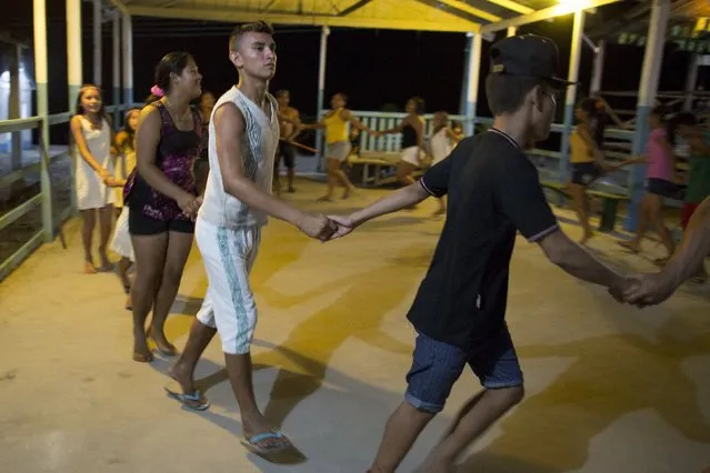 Kambeba Indian, Dream Braga (C), 18, dances with friends at the village Tres Unidos, Amazon state May 9, 2015. (Photo by Bruno Kelly/Reuters)