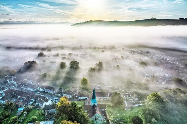 Mist over the village of South Harting, West Sussex morning October 13, 2021, with the rise of the South Downs visible behind. Settled weather is predicted for most of Britain over the next few days. (Photo by Chris Gorman/Big Ladder)