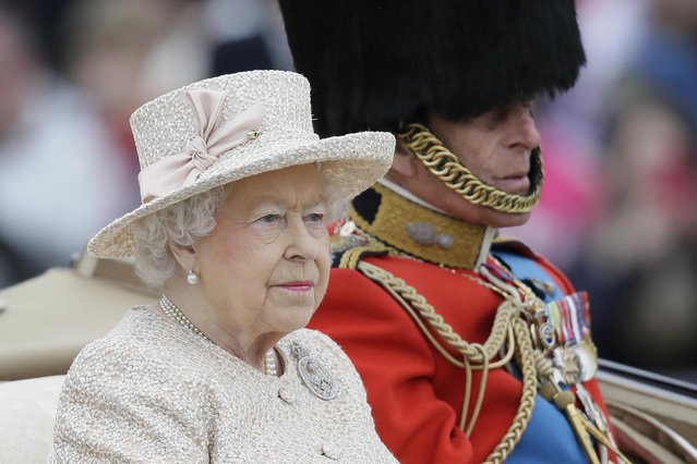 Britain's Queen Elizabeth II and Prince Philip ride in a carriage during the Trooping The Colour parade at Buckingham Palace, in London, Saturday, June 13, 2015. Hundreds of soldiers in ceremonial dress have marched in London in the annual Trooping the Color parade to mark the official birthday of Queen Elizabeth II. The Trooping the Color tradition originates from preparations for battle, when flags were carried or "trooped" down the rank for soldiers to see. (AP Photo/Tim Ireland)