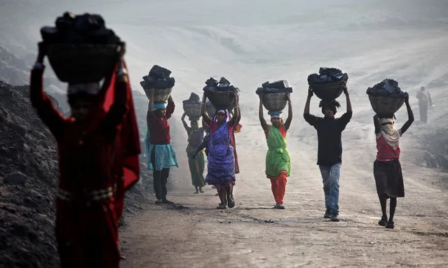 Villagers carry illegally scavenged coal from an open-cast coal mine in Dhanbad, Jharkhand, India on December 6, 2014, trying to earn a few dollars a day. Indian government lead by Prime Minister Narendra Modi plans to double its coal production by 2019. (Photo by Kuni Takahashi/Getty Images)