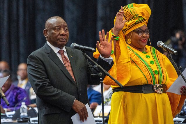 South African président Cyril Ramaphosa raises his hand as he is sworn is as a member of Parliament ahead of an expected vote by lawmakers to decide if he is reelected as leader of the country in Cape Town, South Africa, Friday, June 14, 2024. At right is Pemmy Majodina, an ANC lawmaker. (Photo by Jerome Delay/AP Photo)