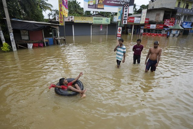 A boy plays with an inflatable rubber tube in a flooded street in Biyagama, a suburb of Colombo, Sri Lanka, Monday, June 3, 2023. Sri Lanka closed schools on Monday as heavy rains triggered floods and mudslides in many parts of the island nation, killing at least 10 people while six others have gone missing, officials said. (Photo by Eranga Jayawardena/AP Photo)